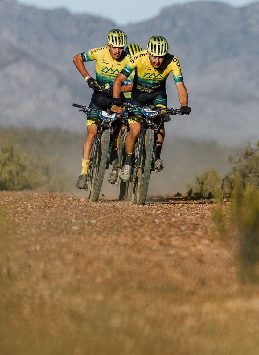 Action shot of mountain bikers wearing custom racing team cycling apparel made by enjoy.cc