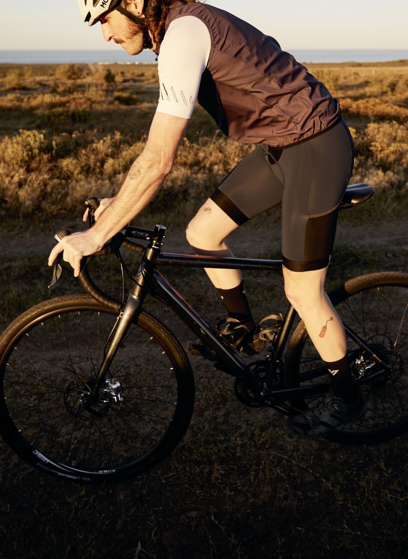Male cyclist wearing the slate mens Atom gilet designed and manufactured by Enjoy.cc