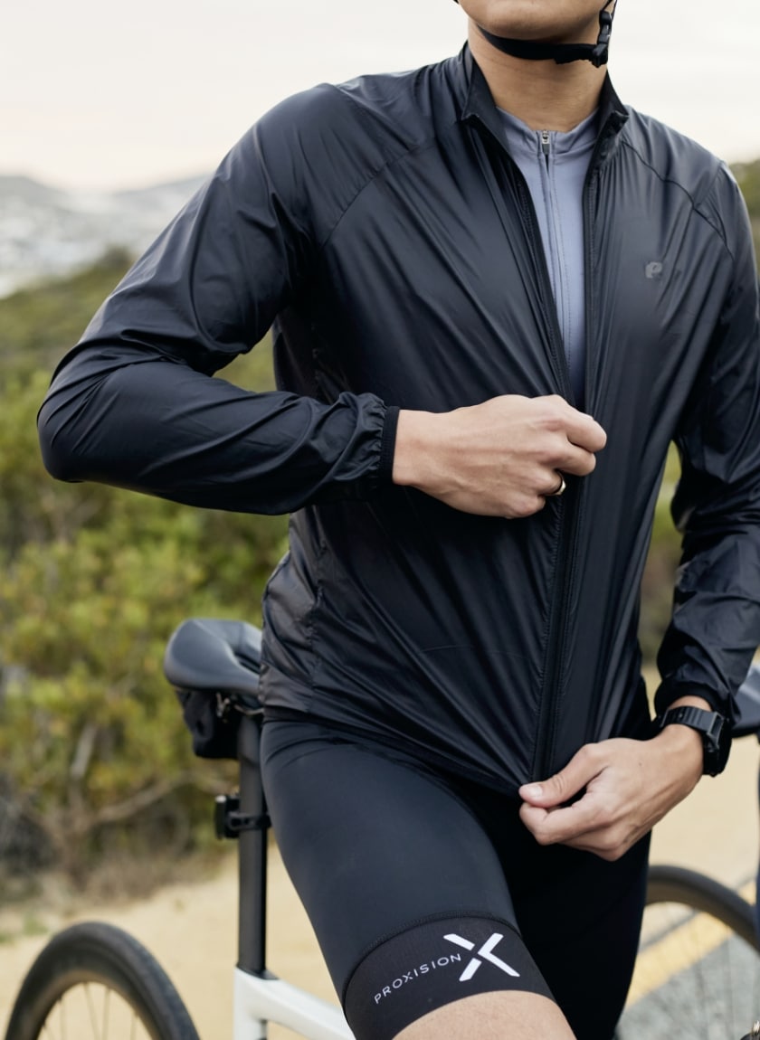 Male cyclist zipping up a water resistant cycling jacket designed and manufactured by Enjoy.cc
