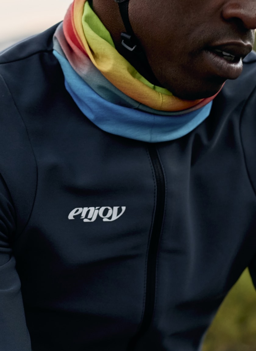 Male cyclist wearing an Enjoy neckwarmer in the Rainbow Nation design available at Enjoy.cc