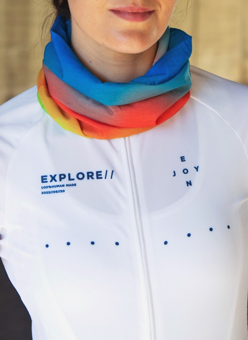 Female cyclist wearing an Enjoy neckwarmer in the Rainbow Nation design available at Enjoy.cc