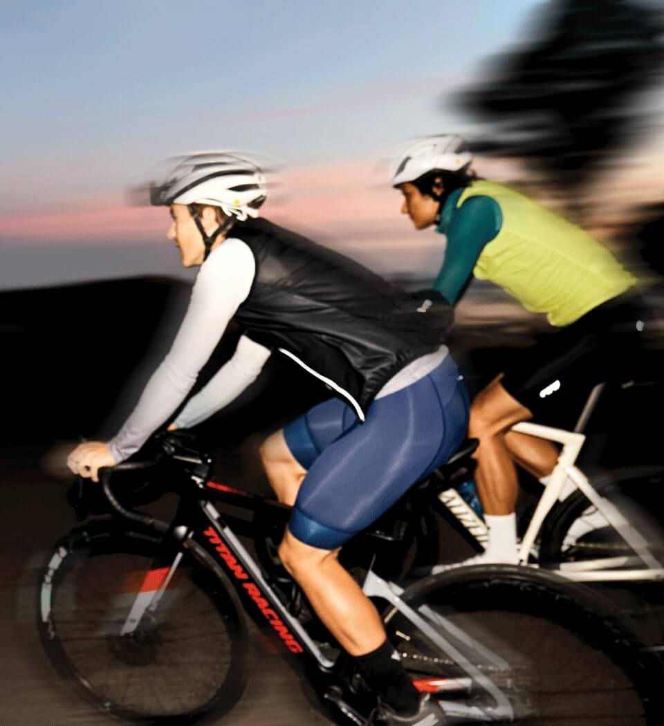 Two cyclists at sunrise wearing Enjoy's Scruncher gilets available at enjoy.cc