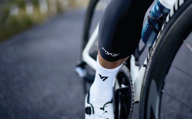 Male cyclist wearing thermal cycling knee warmers made by Enjoy.cc